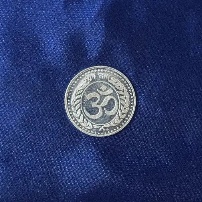 Silver coin with a symbol on a blue fabric background