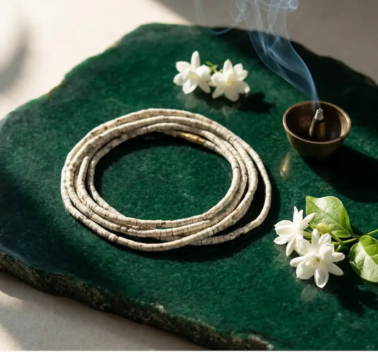 Double round Tulsi Kanthi Mala -8mm  on a green stone surface with incense and white jasmine flowers