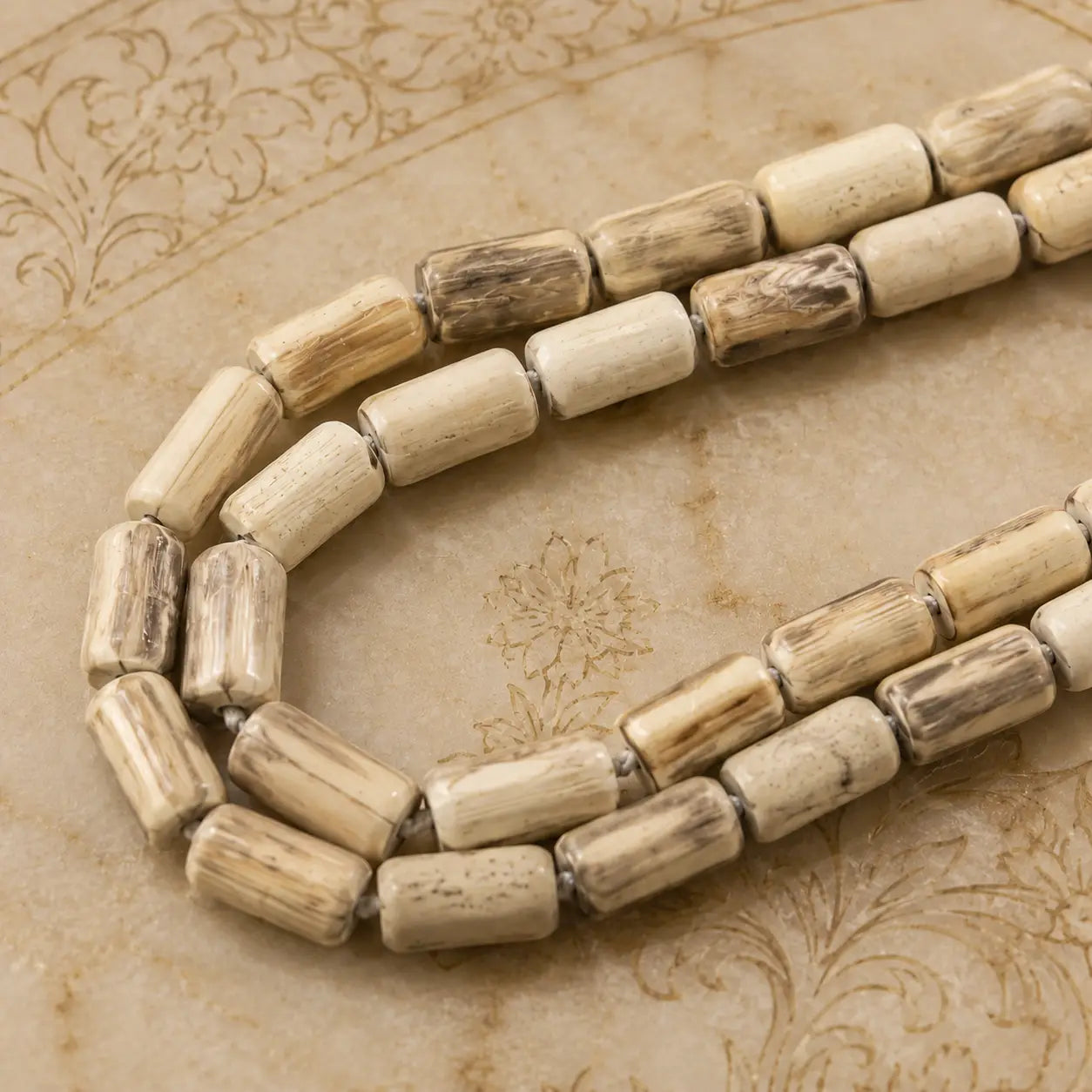 Enlarged original Radha Madhav Tulsi Kanthi Mala double round 10 mm placed on a wooden plate